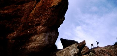 Hikers dwarfed by the High Peaks rock formations at Pinnacles